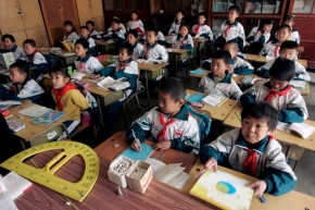 epa00980154 Students attend class at the Zheng Xing School for children of migrant workers in the outskirts of Beijing, Monday 09 April 2007.  The school has three campuses with a total of over 1,200 students.  The basic primary education of thousands of such children remains threatened by their legal status as children of migrant workers that lack residence permits in Beijing.  Authorities in China's capital shut down over 30 such schools deemed unsafe or unfit last autumn and 10,000 children were unable to attend school.  China's economic prosperity in recent years has been largely due to the immense workforce of over 120 million plus migrant workers in the nation's urban areas.  EPA/MICHAEL REYNOLDS